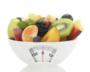 Diet meal. Fruit salad in a bowl with weight scale
