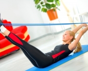 Young woman doing fitness exercises with expander at home