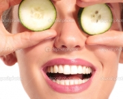 Young beautiflul smiling girl applying a cucumber beauty treatment